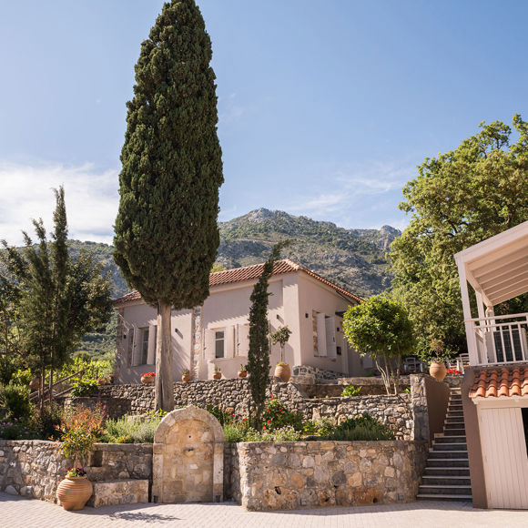 Charming stone pathways and traditional architecture surrounded by lush greenery at Avdou Collection Crete