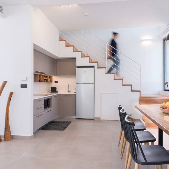 Grand villa modern kitchen with dining table, wooden chairs and staircase view at Avdou Collection Crete