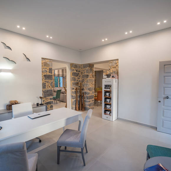 Bright and welcoming lobby with stone wall details, elegant desk and comfortable seating at Avdou Collection Crete
