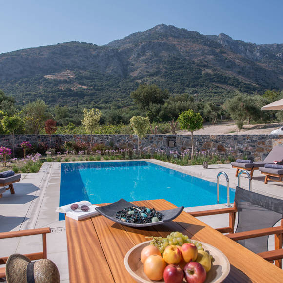 Grand villa poolside with sunbeds, umbrellas, fruit bowl and mountain view at Avdou Collection Crete