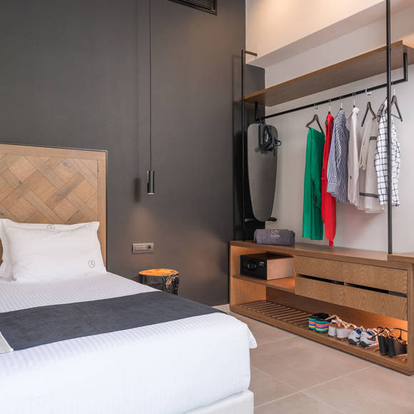 Grand villa master bedroom with wooden headboard, open wardrobe, safe box and desk in modern design