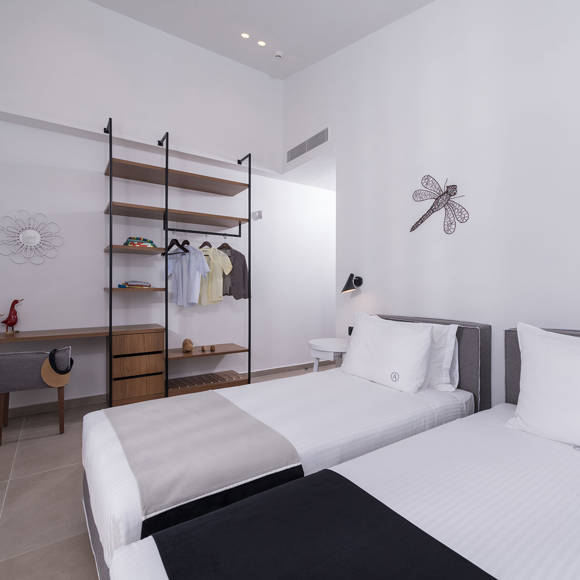 Three bedroom grand villa bedroom with twin beds, open wardrobe with shelves and work desk with modern design