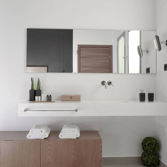 Grand villa bathroom with large mirror, sink, fresh towels and natural details in minimal design at Avdou Collection