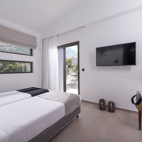 Three bedroom grand villa with twin beds, wall mounted TV, work desk an mountain view window at Avdou Collection