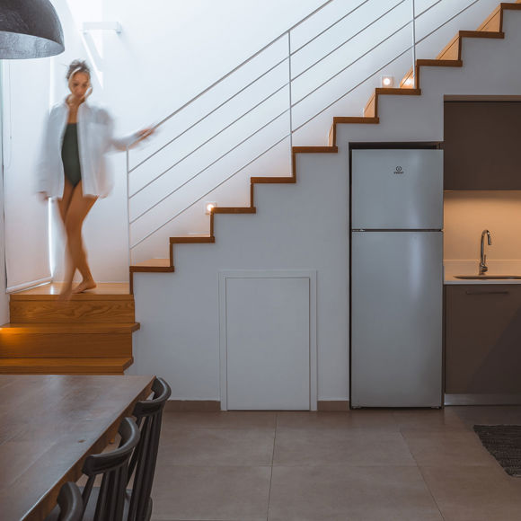 Modern villa kitchen and dining area with wooden stairs and soft lighting at Avdou Collection Crete