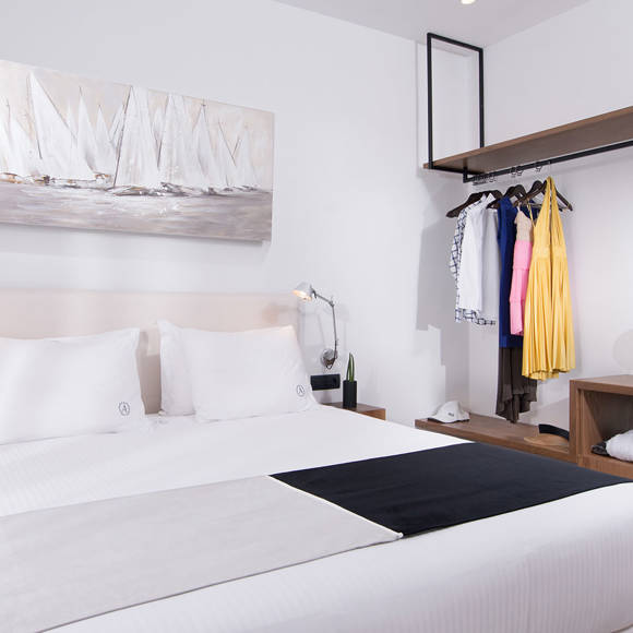 Three bedroom grand villa with double bed, open wardrobe with clothes and desk with chair at Avdou Collection Crete