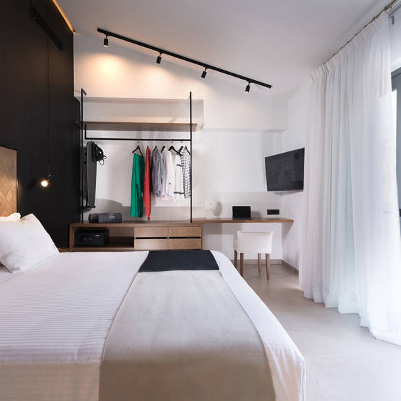 Master bedroom with king size bed, modern design, open wardrobe and balcony in the two bedroom grand villa