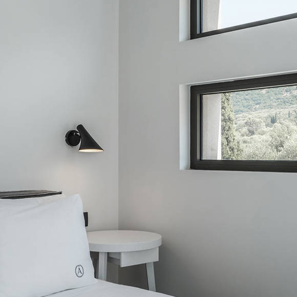 Grand villa with three bedrooms featuring bright interiors, soft bedding and window views of the Cretan landscape